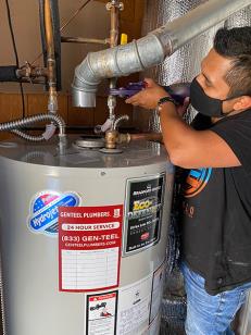 A GENTEEL plumber serving Burlingame connecting the pipes on a tank water heater